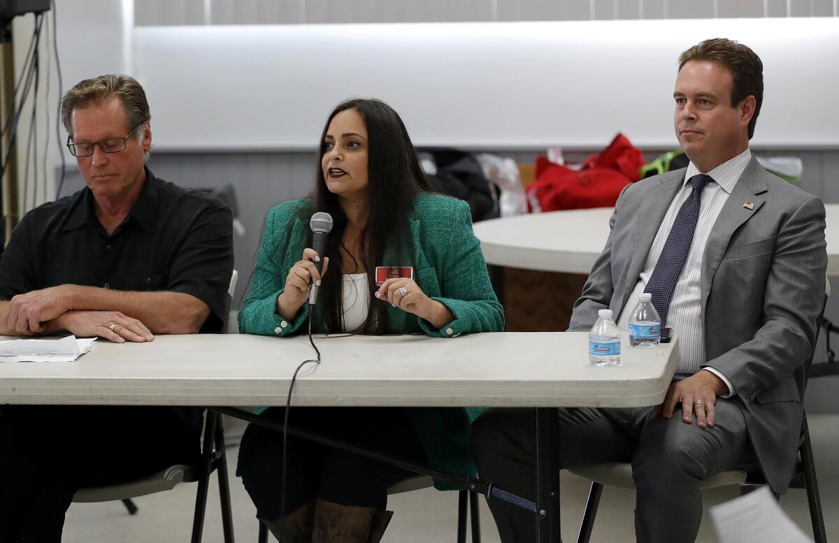 Candidate Gracey Van Der Mark, with microphone, answers an audience question during Friday's forum.