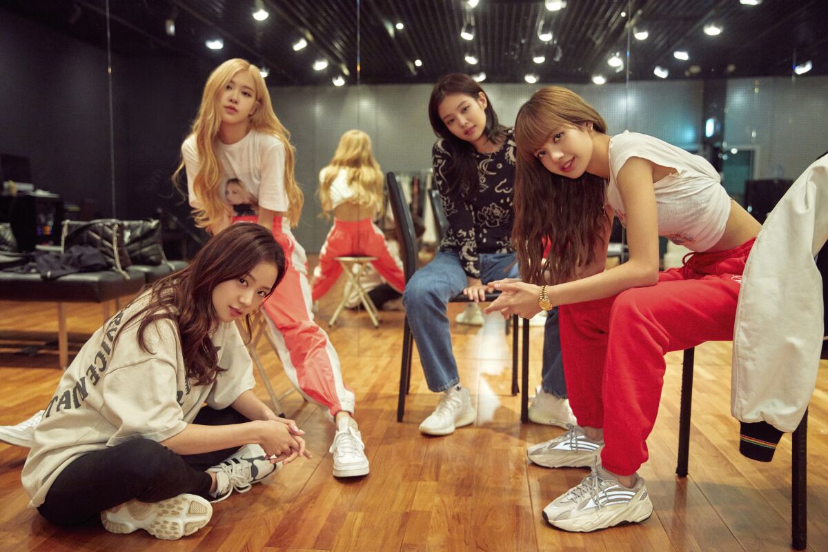 This image released by Netflix shows, from left, Jisoo, seated from left, Rosé, Jennie and Lisa of the K-Pop band Blackpink. The band releases "The Album" on Friday. (Netflix via AP)