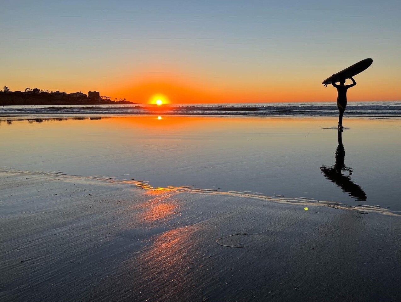 Sunset and a surfer at La Jolla Shores.