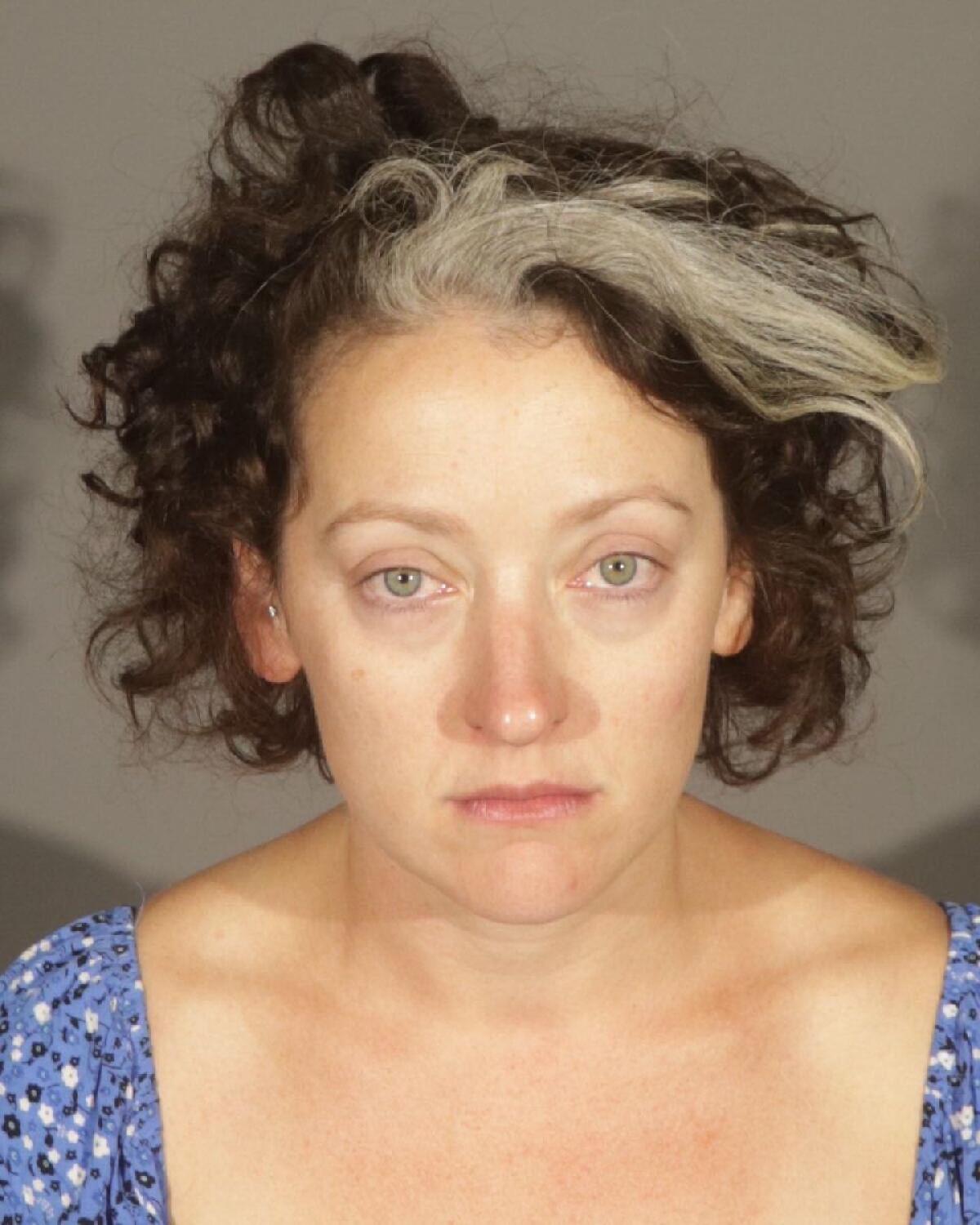 A mug shot of a 37-year-old woman with a white streak in her hair