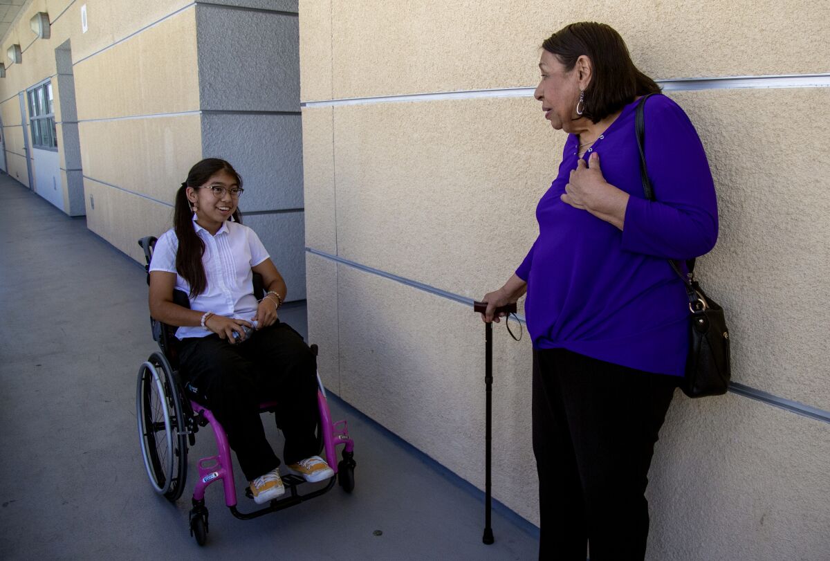 Sylvia Mendez chats with a student outside a classroom at Mendez Fundamental Intermediate School.