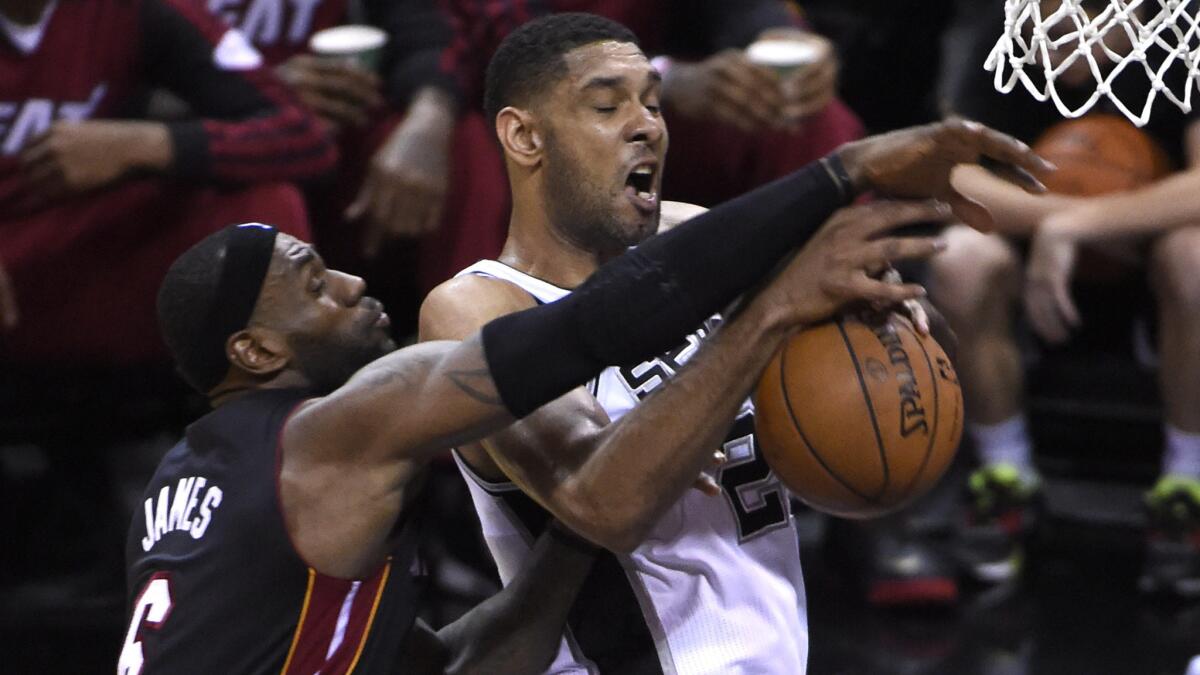 Miami Heat forward LeBron James, left, and San Antonio Spurs forward Tim Duncan battle for a rebound during the Heat's 98-96 win in Game 2 of the NBA Finals on Sunday. The Spurs have struggled in their recent visits to Miami.