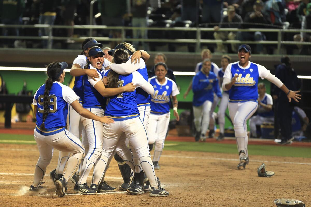 UCLA players celebrate a 2-0 win over Oregon to advance to the Women's College World Series on Sunday. They were holding their final practice for in Oklahoma City when they heard about he fatal shooting at UCLA.