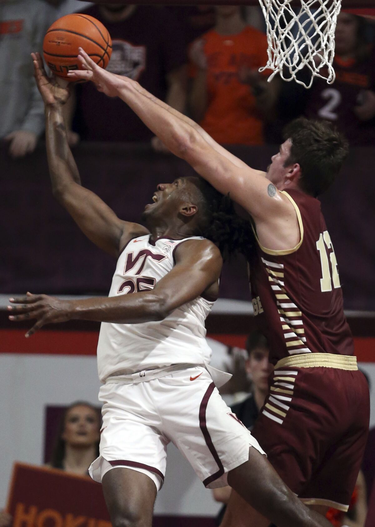 Virginia Tech's Justyn Mutts (25) left, has his shot blocked and is fouled by Boston College's Quinten Post (12) during the first half of an NCAA college basketball game Wednesday, Feb. 8, 2023, in Blacksburg, Va. (Matt Gentry/The Roanoke Times via AP)