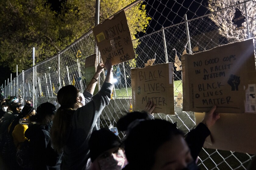 Demonstrators press against a perimeter security fence during a protest over the fatal shooting of Daunte Wright during traffic stop, outside the Brooklyn Center Police Department, Friday, April 16, 2021, in Brooklyn Center, Minn. (AP Photo/John Minchillo)