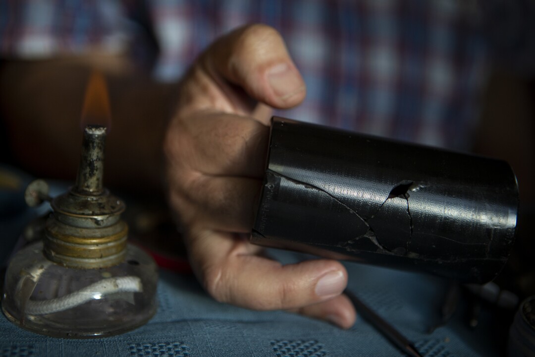 Michael Khanchalian holds a damaged 1905 wax cylinder recording