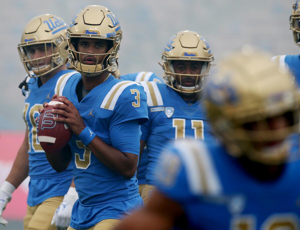 UCLA quarterback Dante Moore warms up before a game 