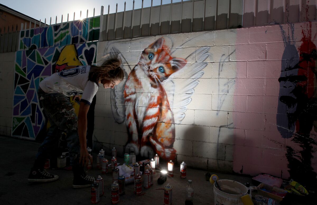 Jules Muck paints a tabby cat with angel's wings.