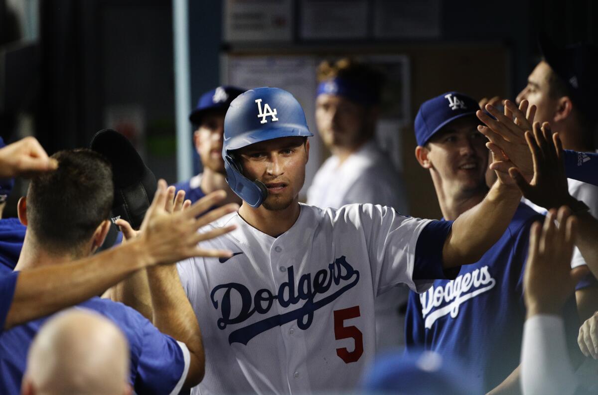 Dodgers shortstop Corey Seager gets high-fives in the dugout after scoring against the Pittsburgh Pirates.