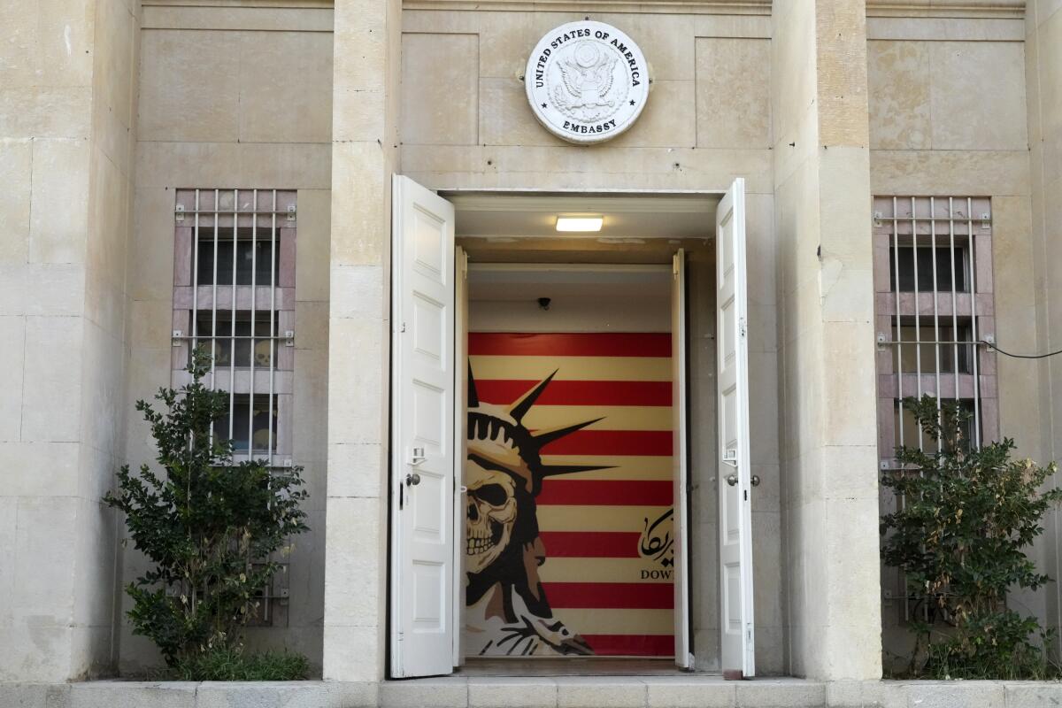 A building entrance has an image of the face of the Statue of Liberty as a skull with red stripes behind it .