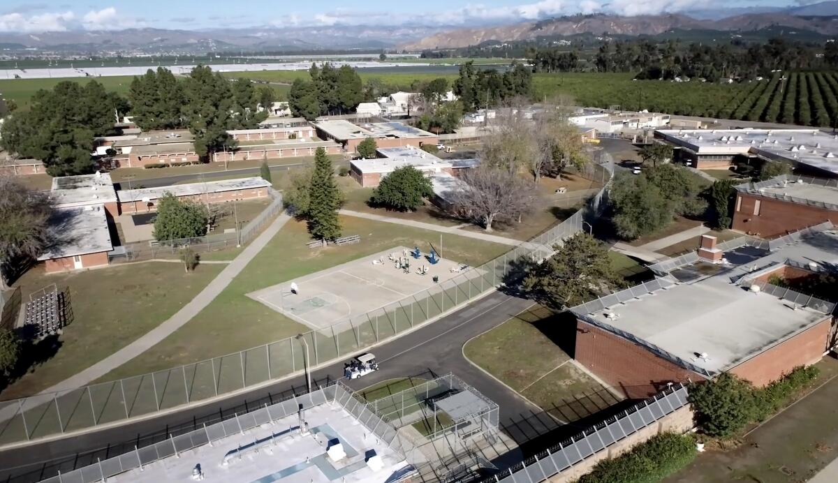 An aerial view of low buildings and fields.