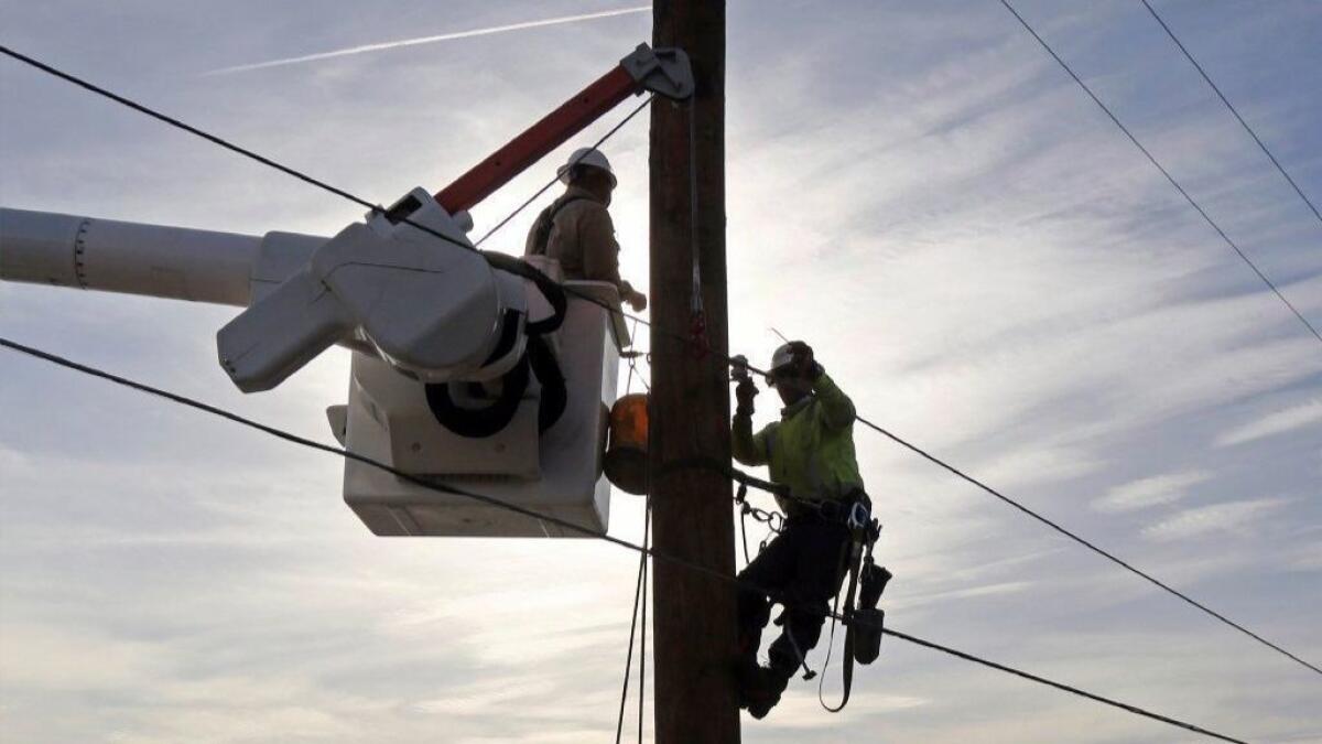 Southern California Edison crews work to replace power poles and lines destroyed by the Woolsey fire along Pacific Coast Highway in Malibu last month.