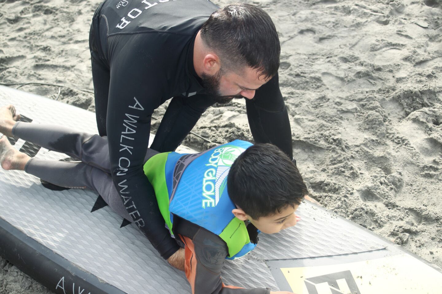 James Short helps Brandon practice on shore before going into the water