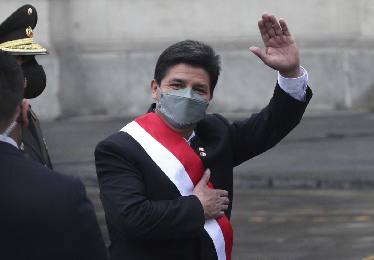 El presidente peruano, Pedro Castillo, saluda a los reporteros cuando sale del palacio de gobierno rumbo a la Catedral