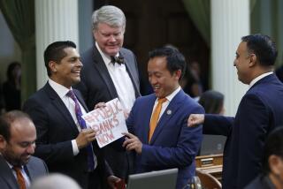 Assemblyman Miguel Santiago, D-Los Angeles, left, presents Assemblyman David Chiu, D-San Francisco, third from left, a note reading #PUBLIC BANKS NOW after Chiu's measure to let California cities create their own public banks, was approved by the Assembly in Sacramento, Calif., Friday, Sept. 13, 2019. Assemblyman Jeff Stone, D-Scotts Valley, second from left, and Assemblyman Ash Kalra, D-San Jose, right, joined in on the celebration. The bill now goes to the governor. (AP Photo/Rich Pedroncelli)
