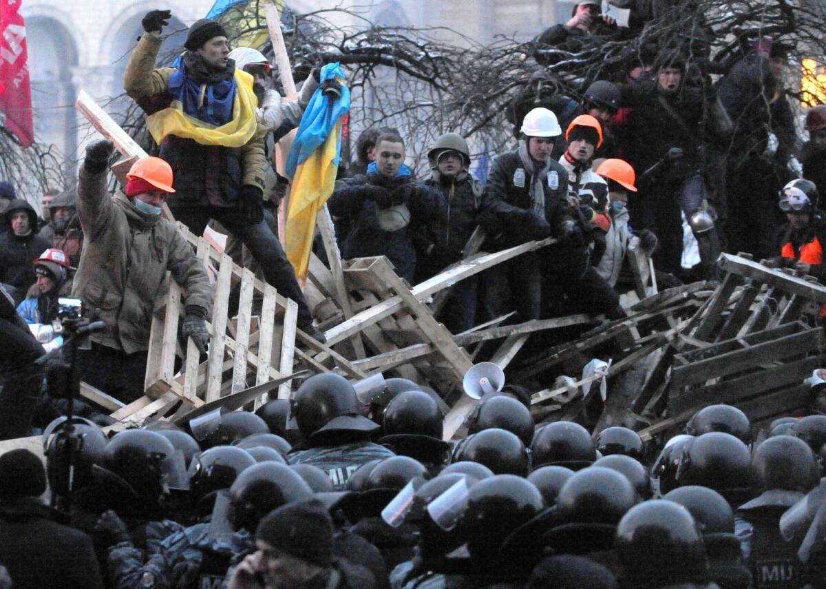 Protesters defend their barricades in front of anti-riot police on Independence Square in Kiev early Wednesday.