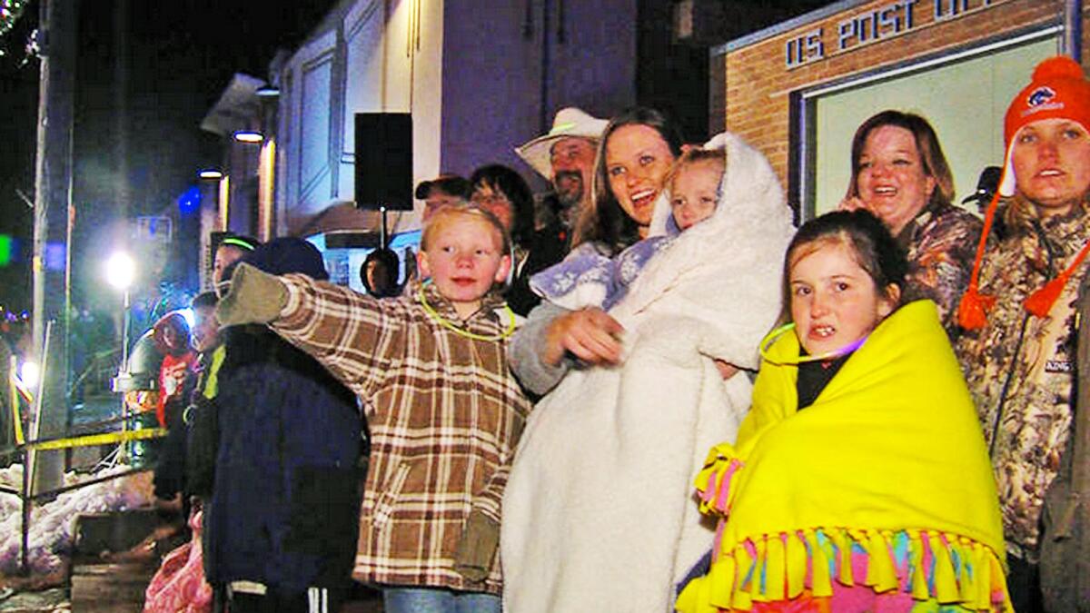 Addie Fausett watches a Christmas parade from the arms of her mother, Tami Fausett, in Fountain Green, Utah.