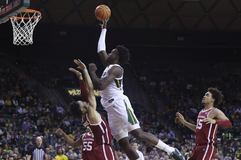 Baylor forward Flo Thamba is by Oklahoma guard Jordan Goldwire during the second half of an NCAA college basketball game Tuesday, Jan. 4, 2022, in Waco, Texas. (AP Photo/Jerry Larson)