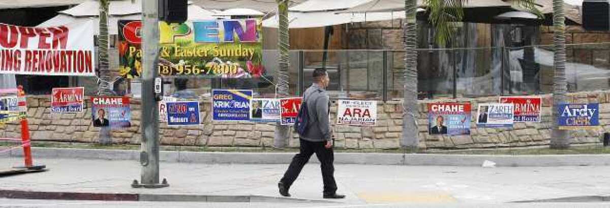 Several election signs in a small strip of grass between the sidewalk and a restaurant patio on the corner of Central Avenue and Lexington Drive in Glendale.