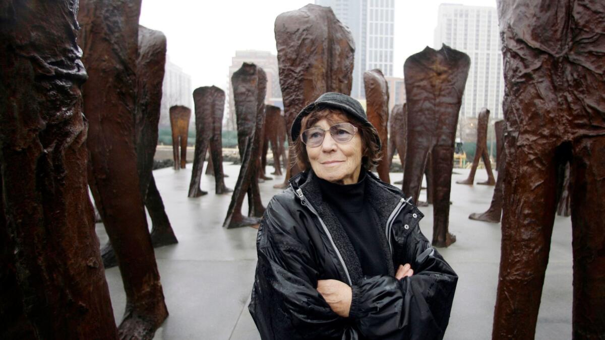 Polish sculptor Magdalena Abakanowicz stands among several of her 106 cast iron human figures as they were being installed in Chicago's Grant Park in 2006.
