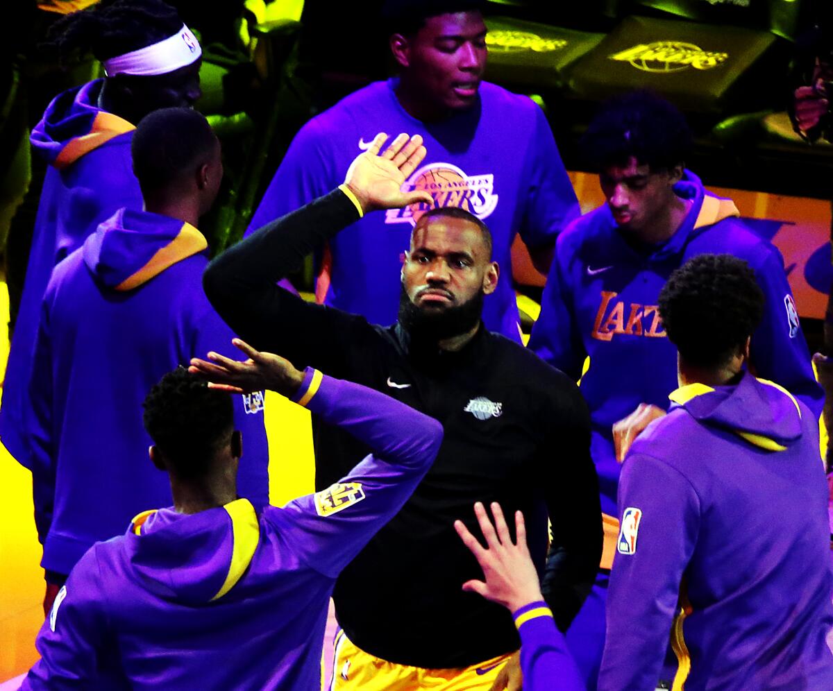 Lakers star LeBron James high-fives teammates as he's introduced before a playoff game.