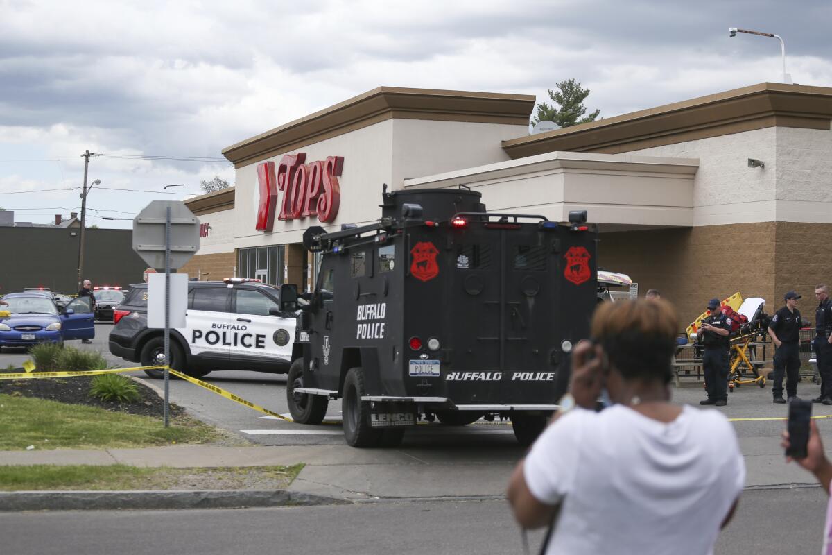 Una multitud se congrega cuando la policía investiga un tiroteo en un supermercado