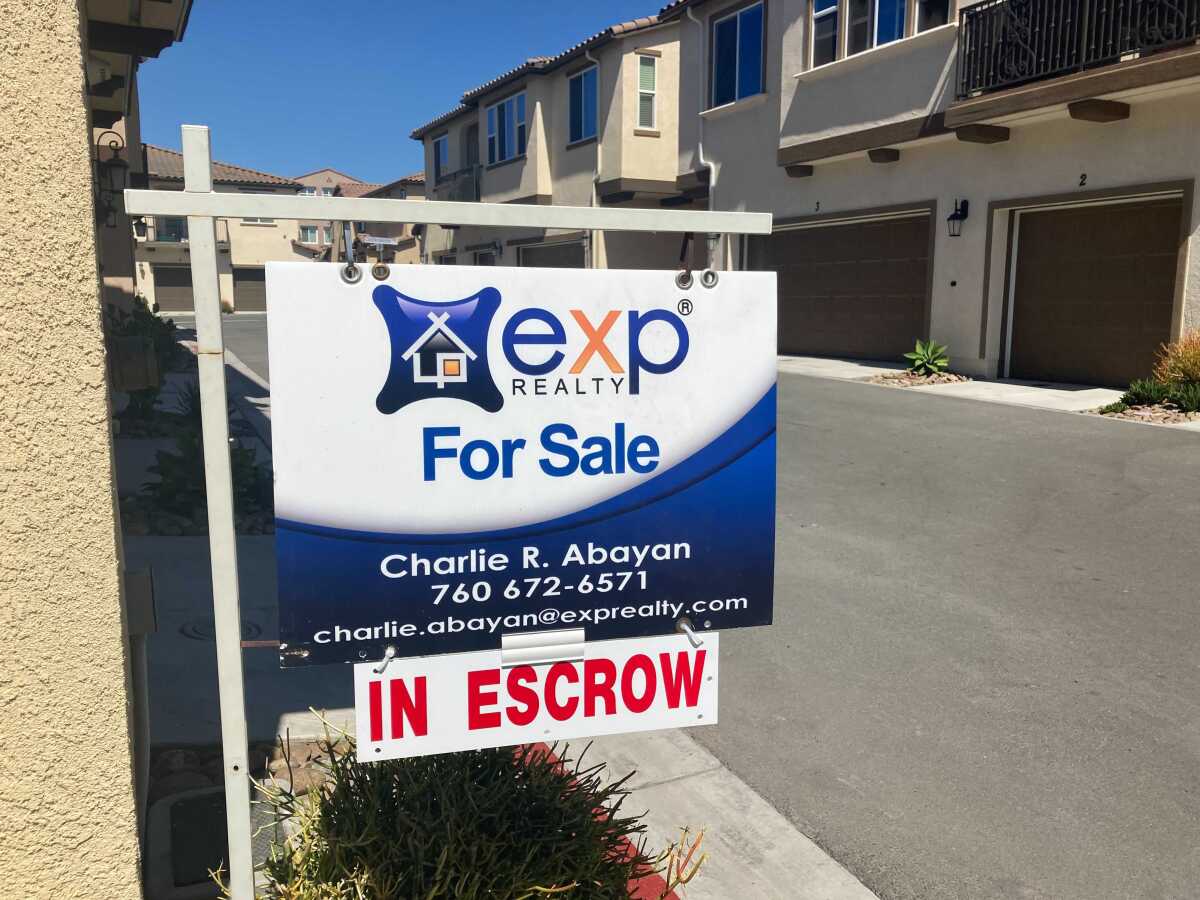 A for-sale sign outside town homes.