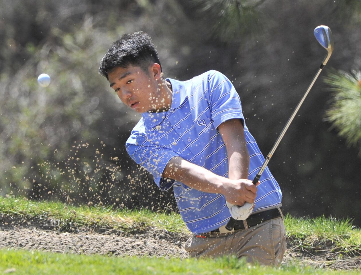 Crescenta Valley's Paul Park hits out of a bunker outside the first green in a Pacific League golf match at De Bell Golf Club in Burbank on Thursday, March 13, 2014.