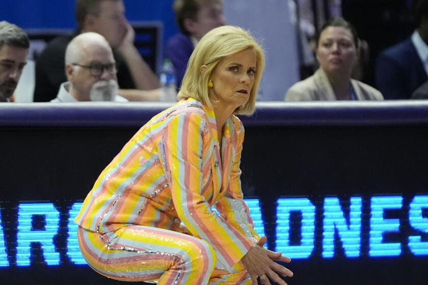 LSU coach Kim Mulkey crouches down and watches from the sideline during an NCAA tournament game against Middle Tennessee 