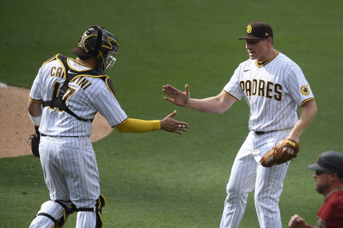 Padres closer Mark Melancon is congratulated by catcher Victor Caratini.
