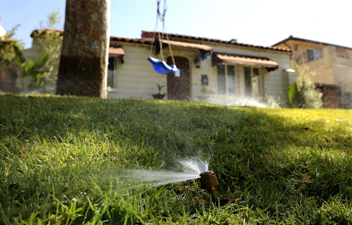 Sprinklers water a lawn at a residence at along Parnell Ave. in Los Angeles.