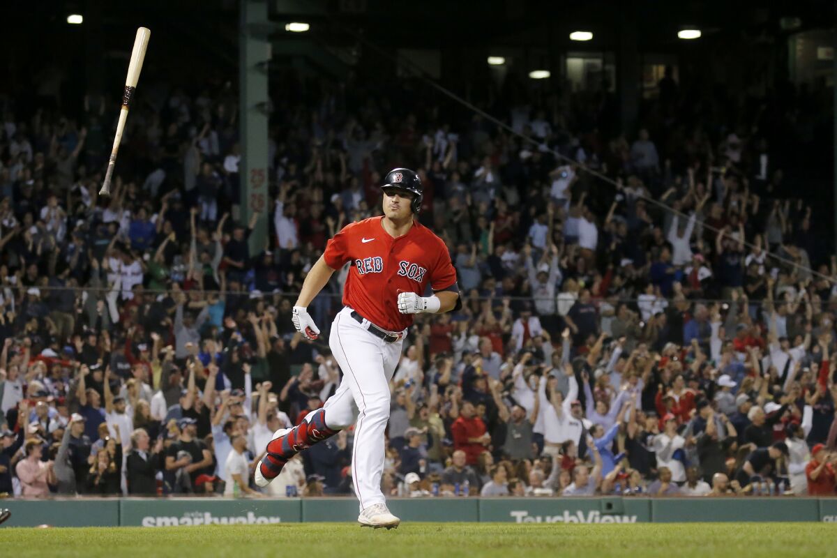 Fans cheer as Boston Red Sox's Hunter Renfroe tosses his bat after hitting a three-run home run during the seventh inning of the team's baseball game against the Cleveland Indians at Fenway Park, Friday, Sept. 3, 2021, in Boston. (AP Photo/Mary Schwalm)