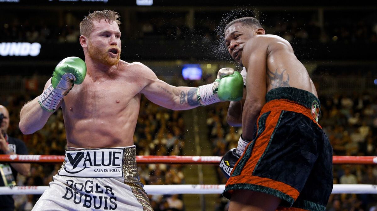 Canelo Alvarez punches Daniel Jacobs during their middleweight title fight in Las Vegas on May 4. Alvarez won by unanimous decision.