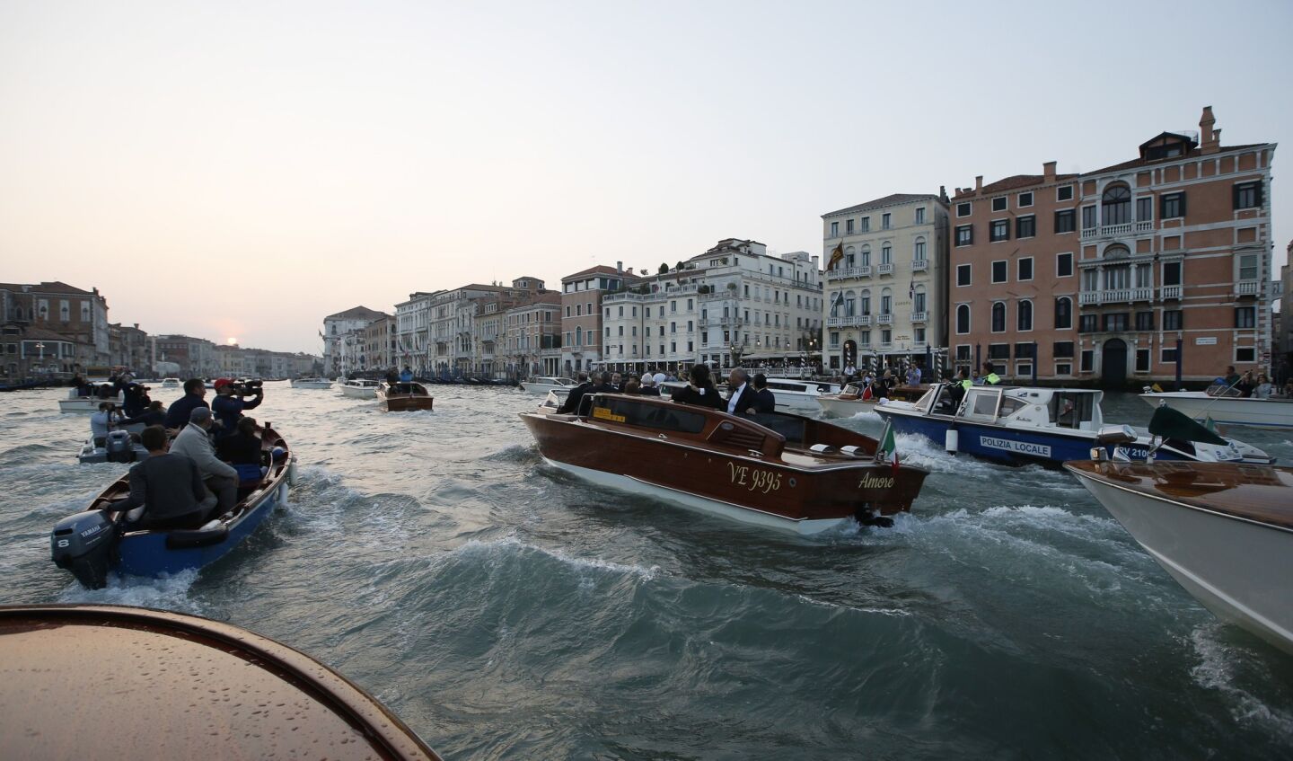A pack of boats kicks up some chop on Venice's Grand Canal around George Clooney's water taxi Saturday afternoon.