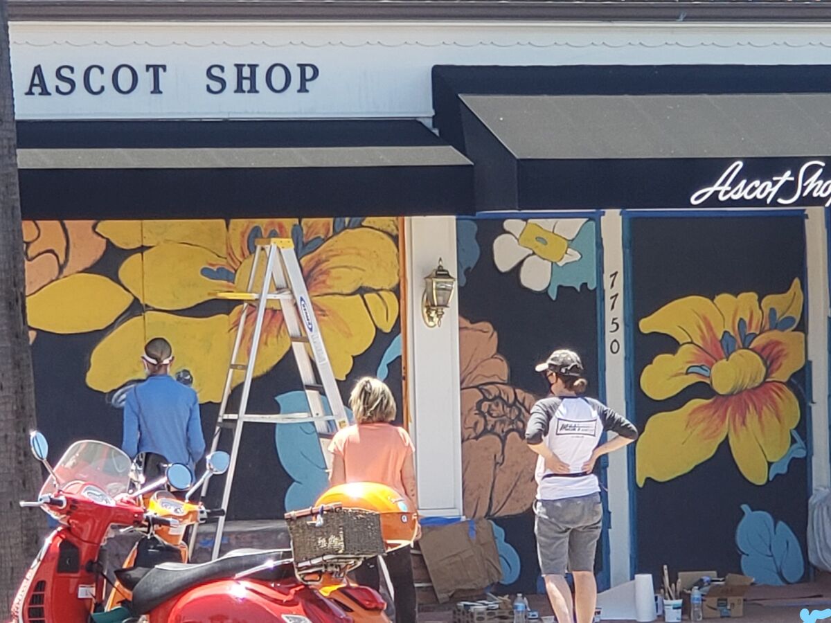 Volunteers paint a mural on the Ascot Shop on Girard Avenue.