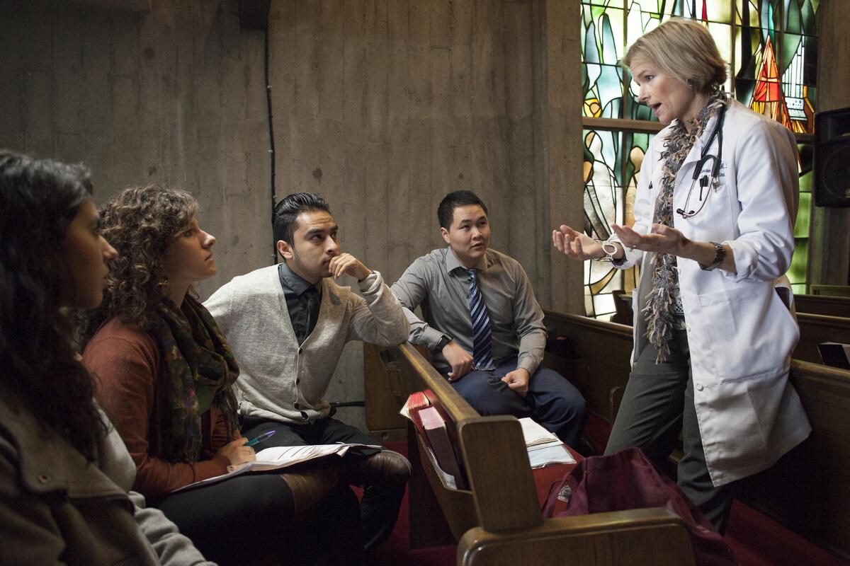 Dr. Cameron Carlen-Jones, right, speaks with UC Irvine students, from left, Alejandra Hurtado, Mackenzie Cater, Oscar Hernandez and Tuan Ngo before they see a patient at a free clinic at United Methodist Church in Garden Grove.