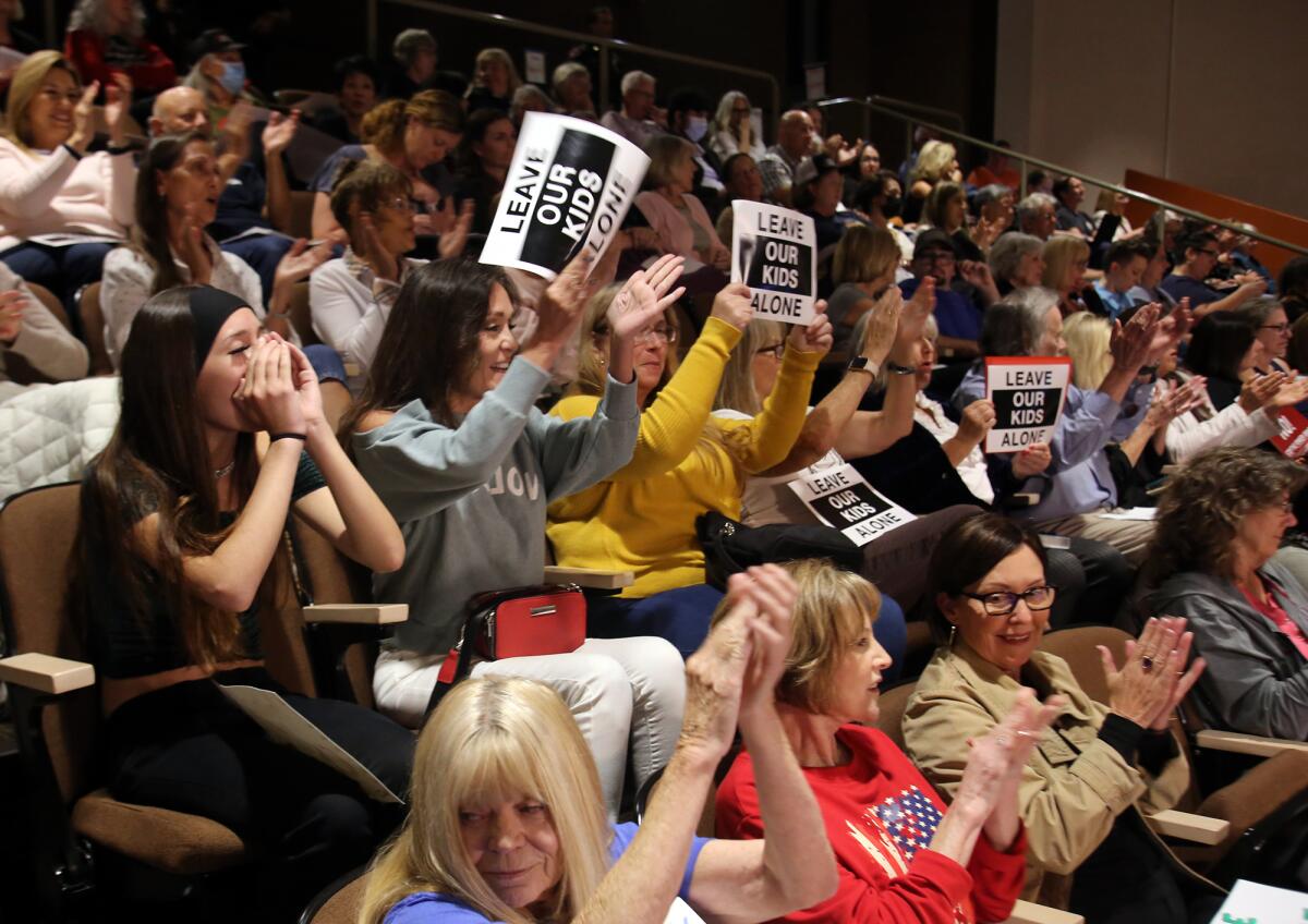 Huntington Beach residents cheer and hold signs during public comments at Tuesday night's meeting.