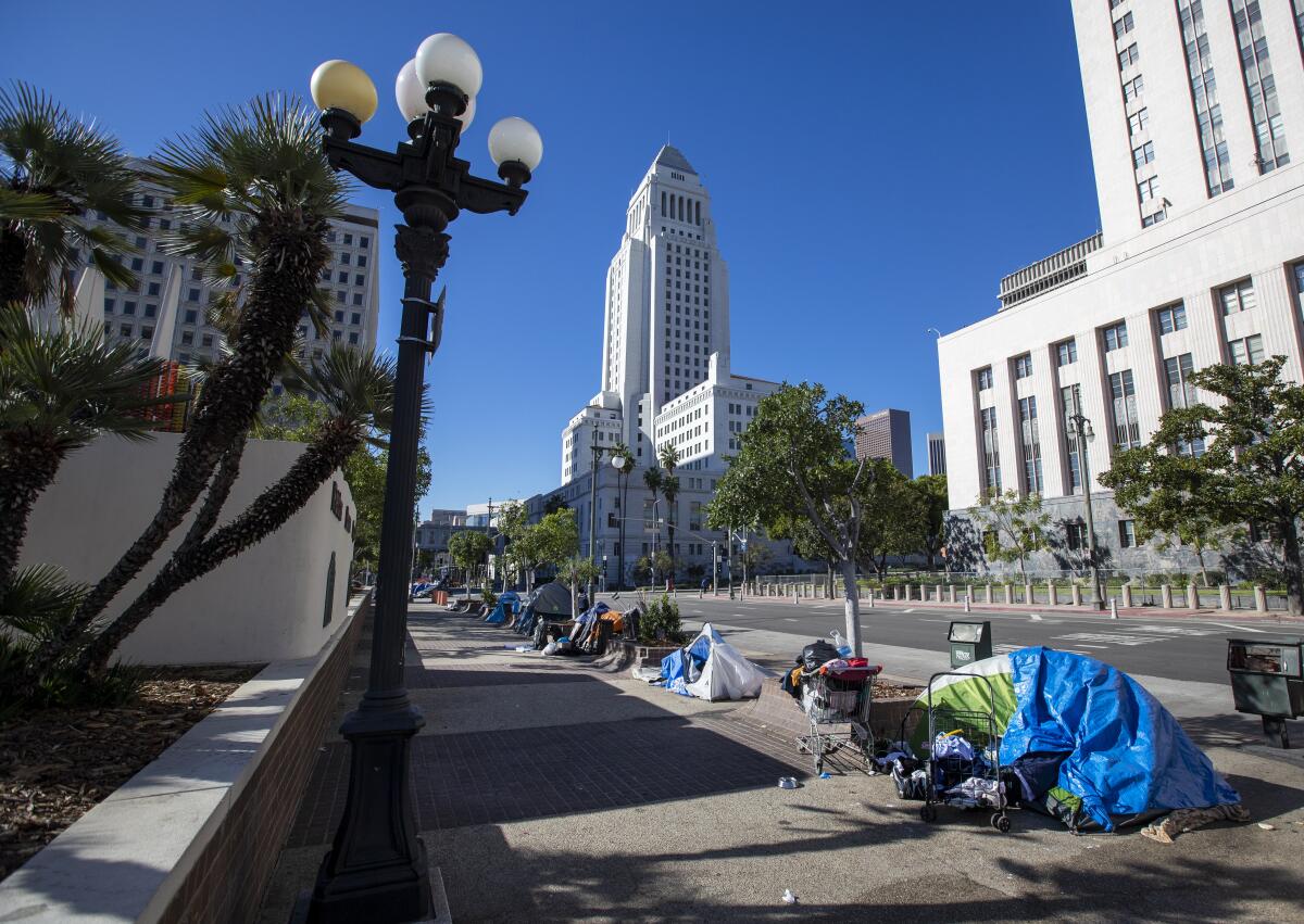 People sleep in tents near City Hall in downtown Los Angeles. 