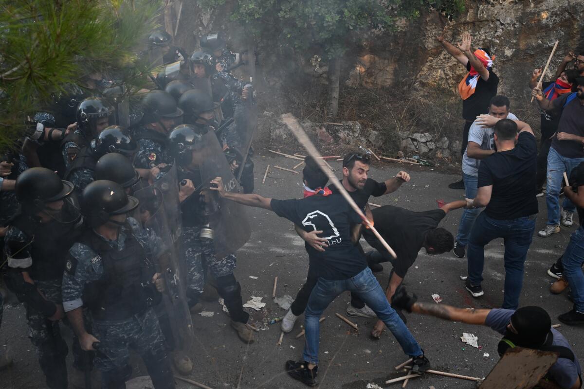 A group of people in helmets and uniforms face people who are moving around.