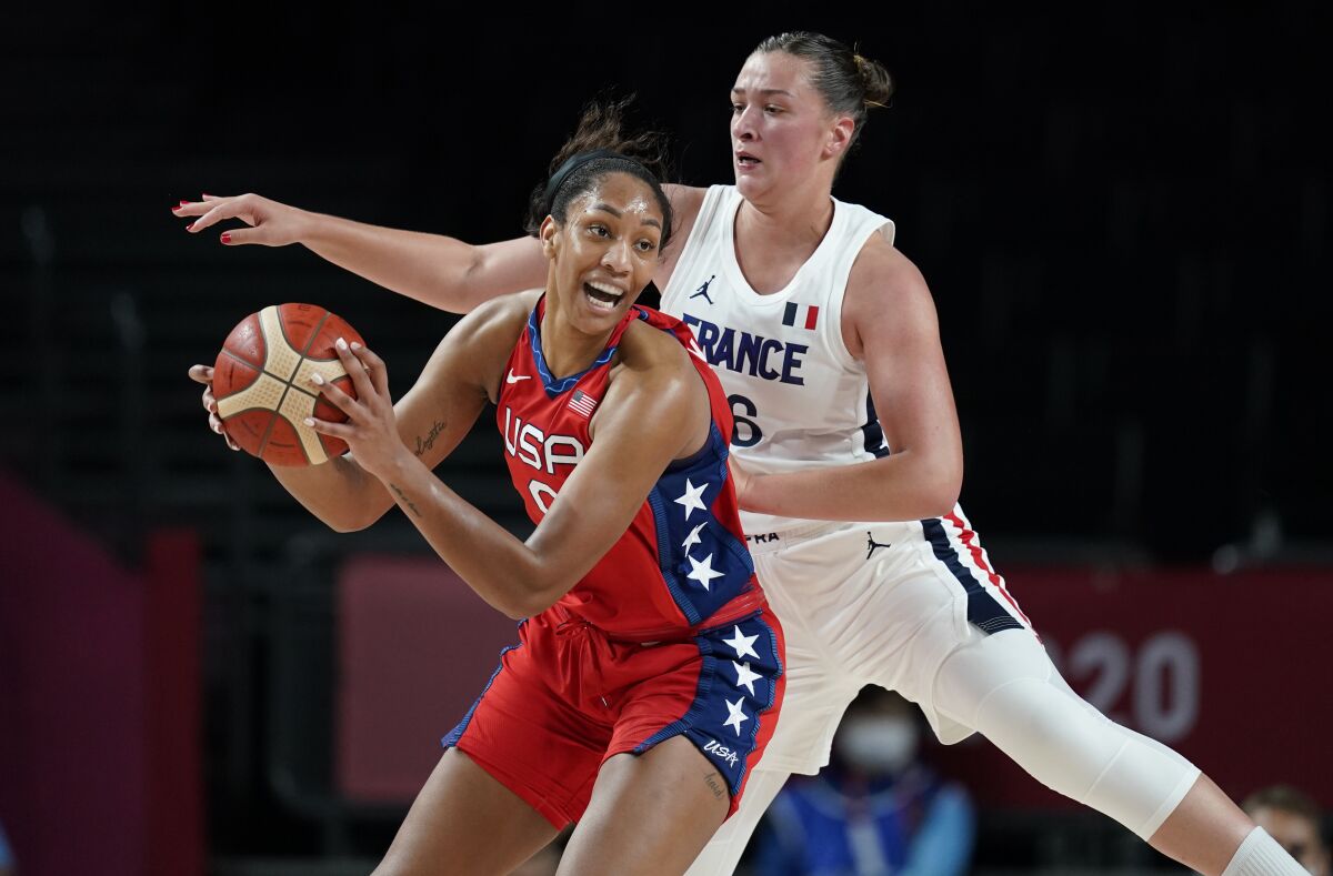 U.S. forward A'Ja Wilson passes in front of France's Alexia Chartereau.