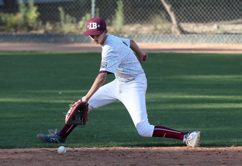 Aaron Crosby scoops up an infield hit during the Laguna Beach Little League Intermediate All-Stars practice on Tuesday.