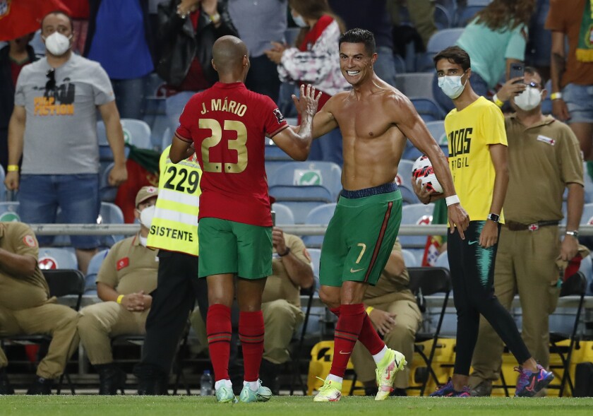 Portugal's Cristiano Ronaldo, right, celebrates after scoring his side's second goal during the World Cup 2022 group A qualifying soccer match between Portugal and the Republic of Ireland at the Algarve stadium outside Faro, Portugal, Wednesday, Sept. 1, 2021. (AP Photo/Armando Franca)