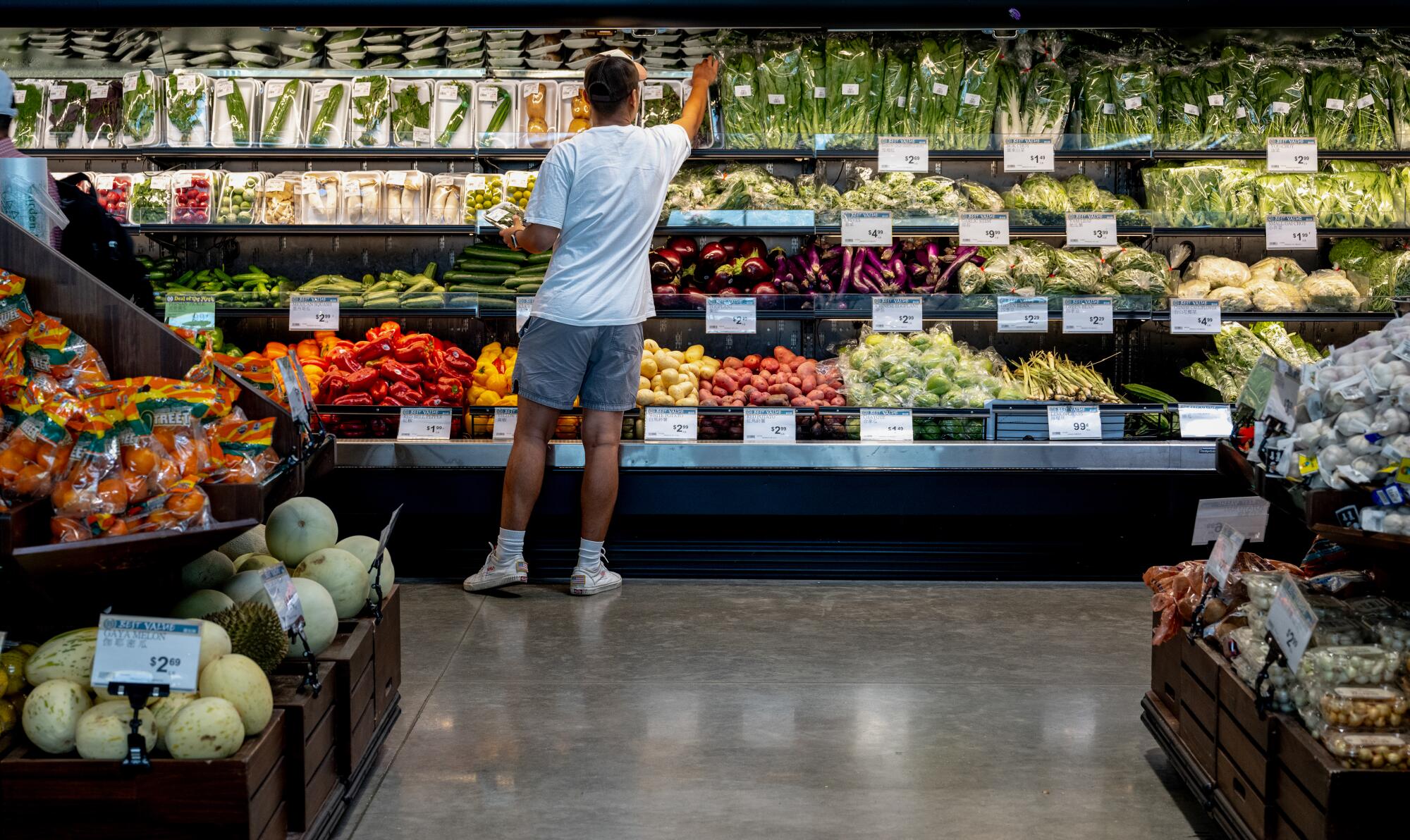 A customer picks out a package of greens from the vast produce area.