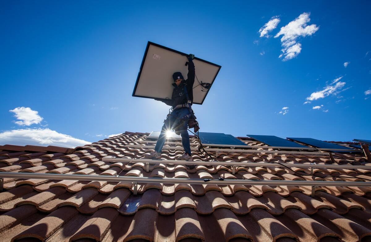 A Sunrun employee installs solar panels on a roof in North Las Vegas in January.