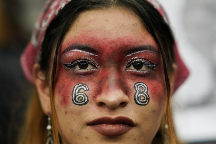 A woman with the number 68 painted on her face participates in a march in remembrance of the 1968 Tlatelolco student massacre in Mexico City, Monday, Oct. 2. 2023. (AP Photo/Eduardo Verdugo)