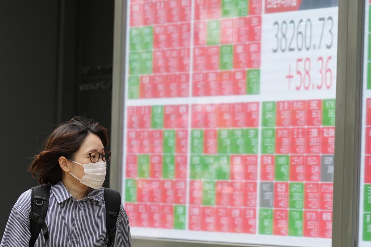 A person looks at an electronic stock board 