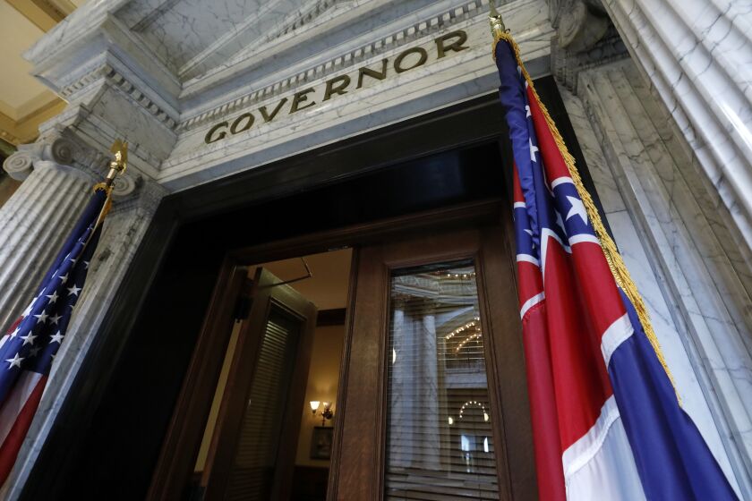 The Mississippi state flag is shown across from the American flag, outside the Governor's Office at the Capitol in Jackson, Miss., Monday, June 29, 2020, the day after both chambers of the state Legislature passed a bill to take down and replace the current flag, which contains the Confederate battle emblem. (AP Photo/Rogelio V. Solis)
