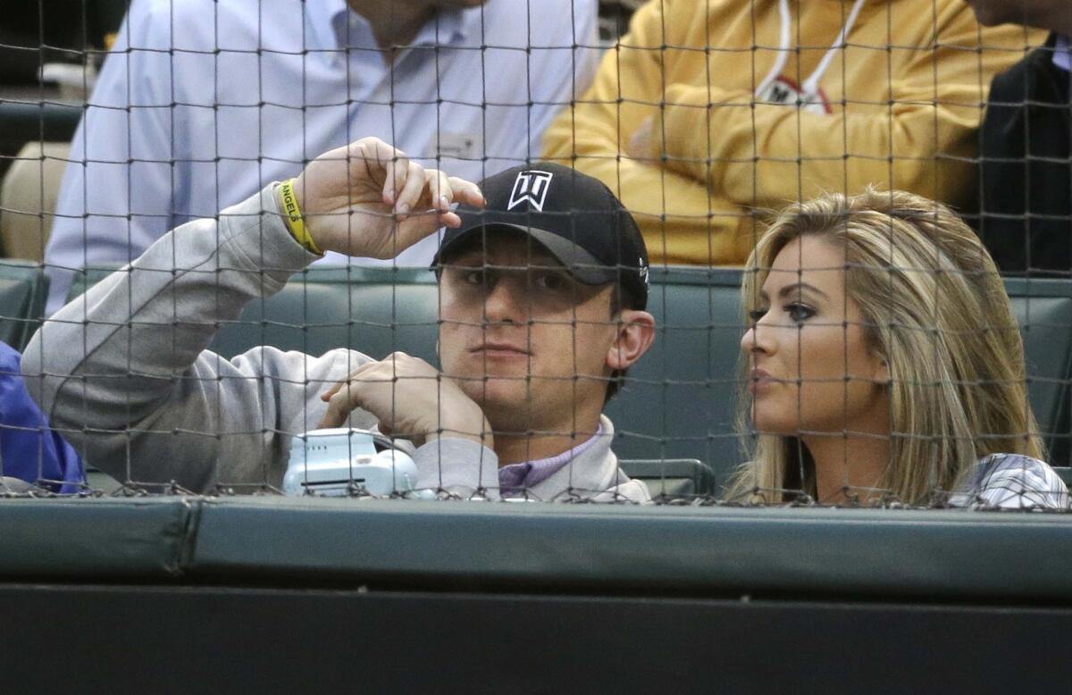Johnny Manziel, left, sits with Colleen Crowley during a baseball game between the Angels and Texas Rangers in Arlington on April 14, 2015.