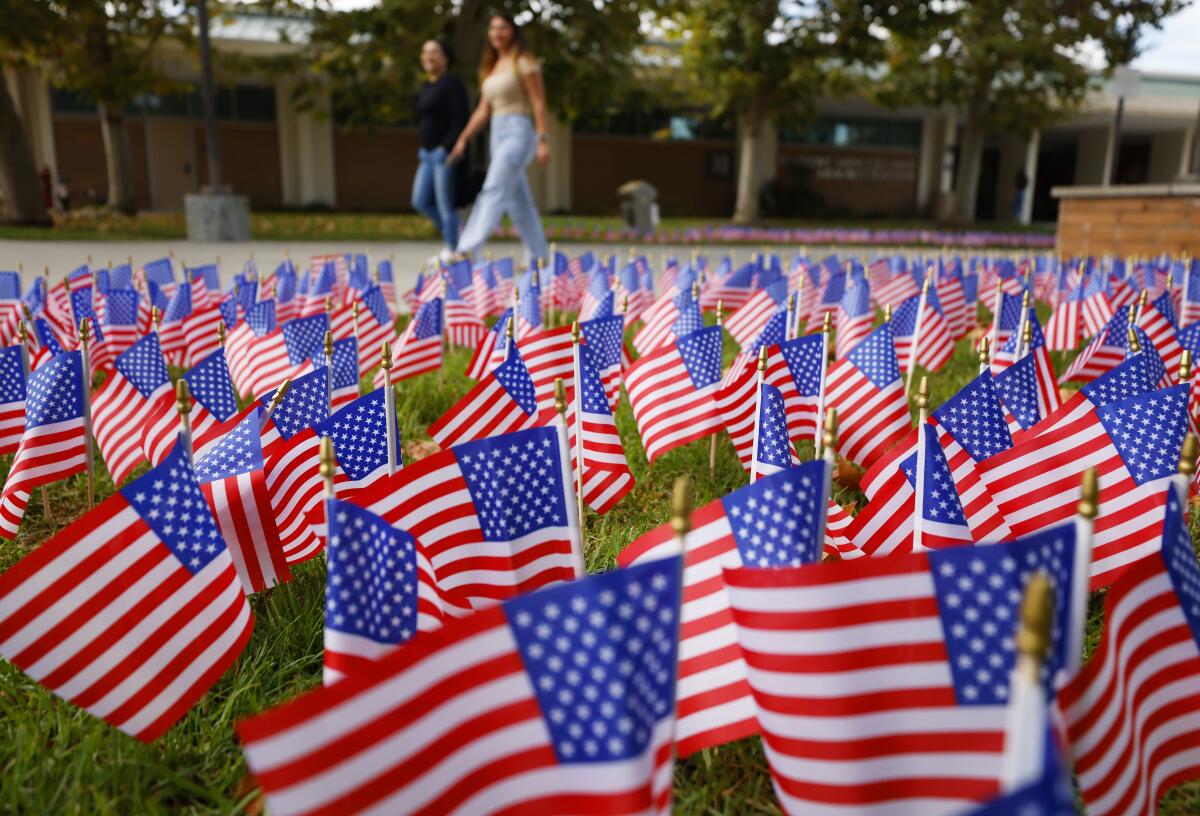Students walk by thousands of American flags during a 9/11 memorial event at Grossmont College in El Cajon.