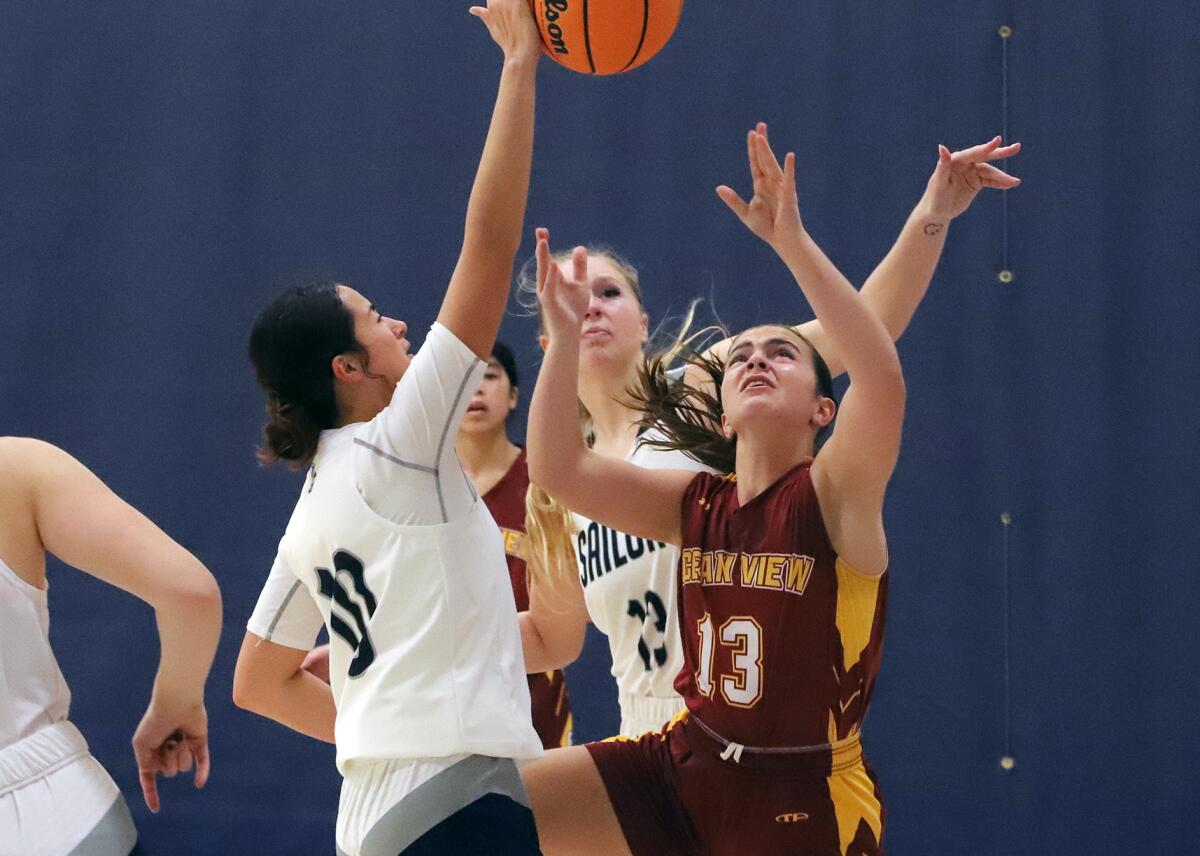 Newport Harbor's Lily Cavanaugh (10) and Ocean View's Angelina Bado (13) reach for a rebound on Friday.